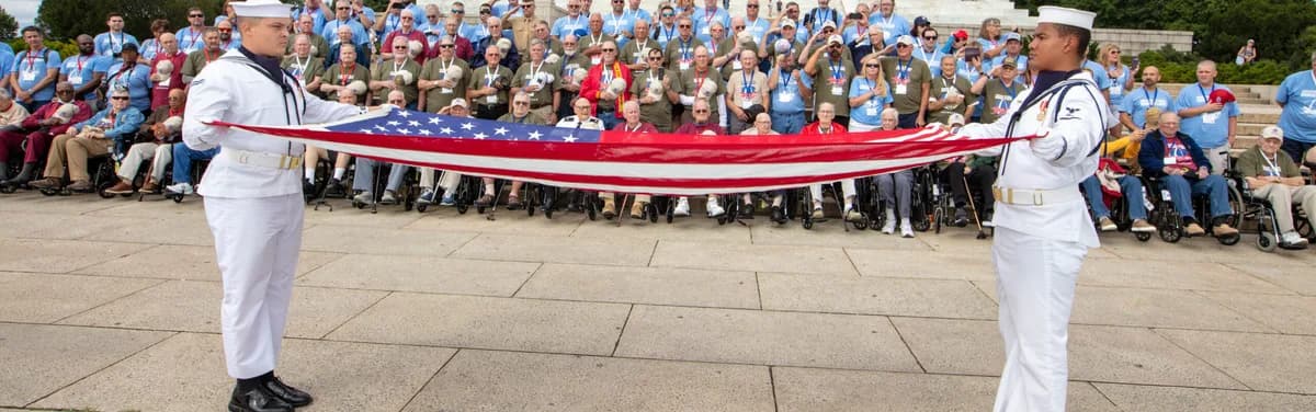 Sailors folding the American flag in front of Veterans at the Lincoln Memorial on their Day of Honor